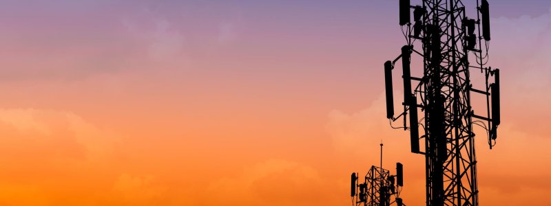 silhouette of communication tower with dusk sky with space for text
